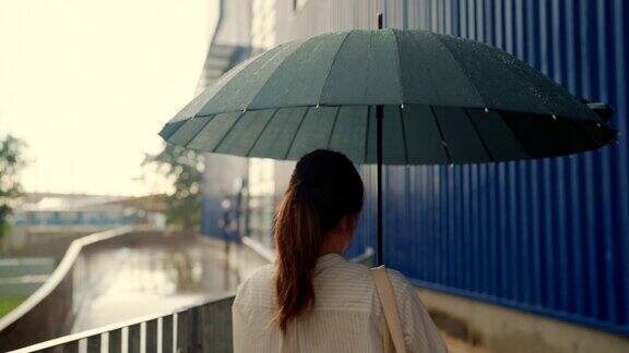 在大雨中撑着伞的女商人孤独而忧伤