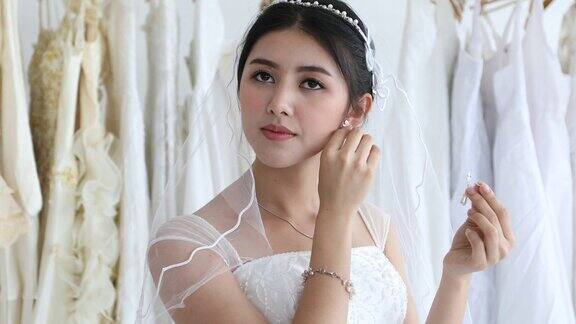 美丽的新娘把她的珠宝和婚礼耳环