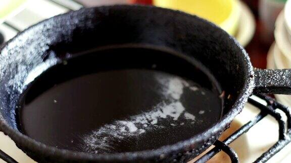 将油倒入煎锅-准备煎炸油热锅-特写上的厨房瓷砖热