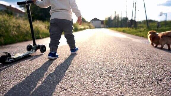 蹒跚学步的小男孩推滑板车