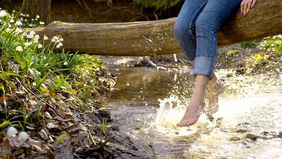 DSSLOMO女人在小溪里刷新她的脚