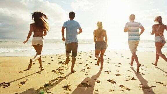 一群朋友在日落时沿着海滩散步