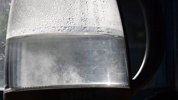 特写未清除的沸水在旧透明水壶与水垢