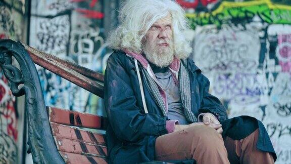 无家可归的老人独自坐在破板凳上贫穷和社会不公