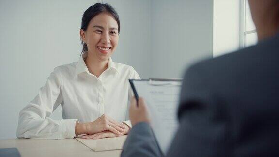 年轻的亚洲女商人面试一份工作同时在办公室讨论简历