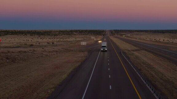 航拍图:黎明时分卡车货运和汽车在公路上行驶