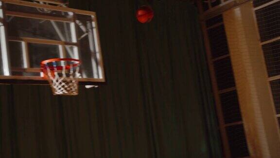 年轻卷曲的职业篮球运动员把球投进篮里夜漆黑剪影错过了