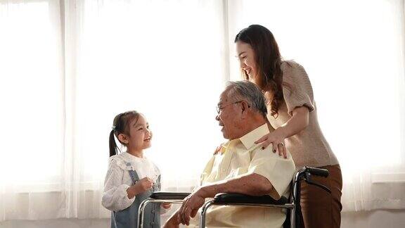 多代母女在家中照顾老爷爷坐在轮椅上幸福快乐老人养老理念