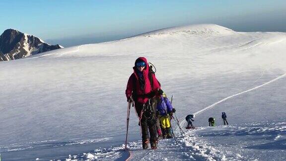 一位疲惫的女登山者和一群朋友从俄罗斯北部攀登卡兹别克山