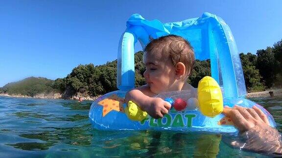 快乐的小宝贝在充气床垫上漂浮在海上