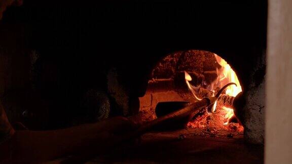 在传统的俄罗斯烤箱里用火烹饪老妇人把锅放在石木烧的炉子里