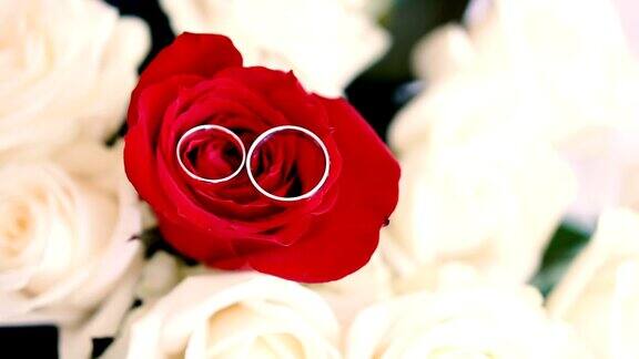 结婚戒指戴在玫瑰花束上新婚夫妇的珠宝婚礼配件