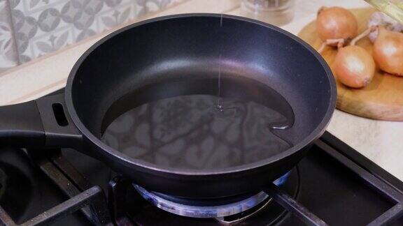 在煎锅上倒油厨师将葵花籽油倒入煎锅