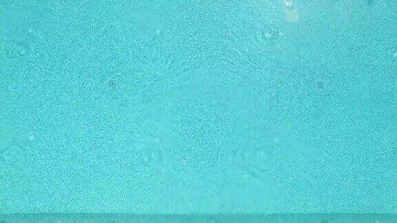 从清澈的绿松石游泳池的水缩小