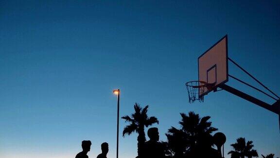 街头打篮球的青少年的剪影