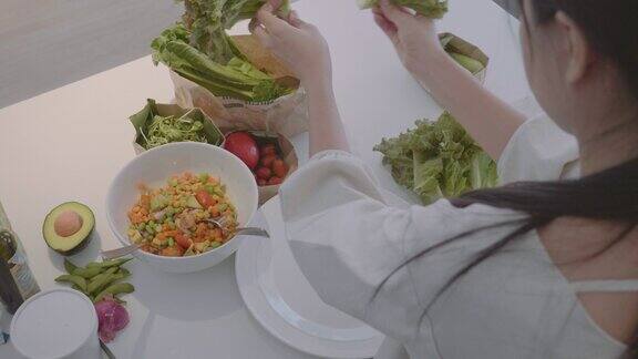 一名妇女在碗里搅拌蔬菜沙拉的配料在碗里搅拌蔬菜沙拉的特写镜头