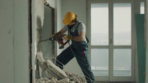 建筑工人正在用电钻拆除墙壁