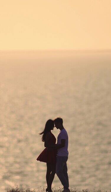 浪漫的情侣站在美丽的海景背景上