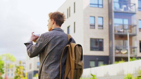 一个年轻人背着背包在城市里喝咖啡