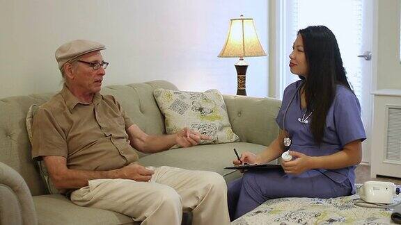 资深白种人在家与亚裔看护者交谈