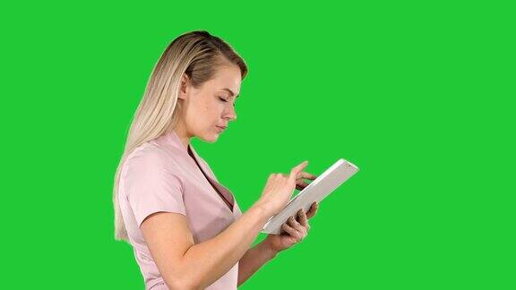 女孩拿着平板电脑在绿屏上找东西色度键
