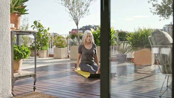 退休妇女在户外甲板上做瑜伽