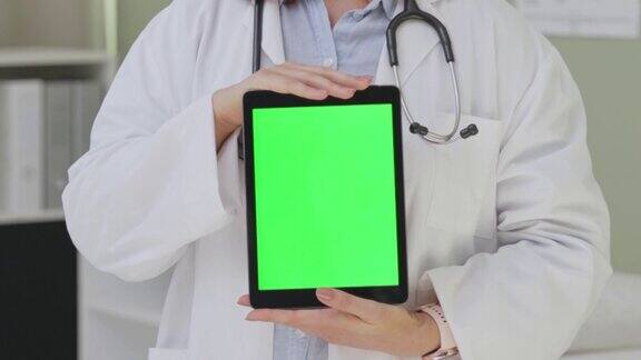 一名女医生手持绿色屏幕的数字平板电脑的4k视频片段