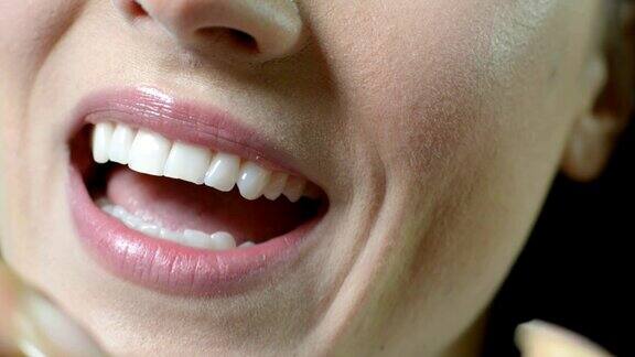 女人用牙线清洁洁白牙齿的特写