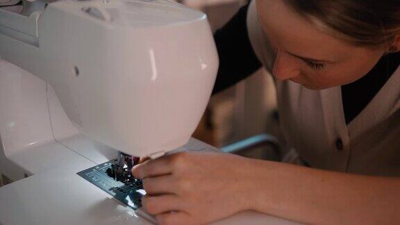 一名无法辨认的女裁缝在缝纫机上准备缝纫针