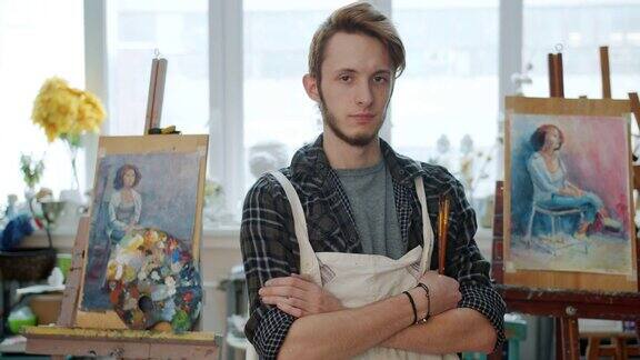 肖像的创意青年艺术家站在绘画工作室拿着画笔