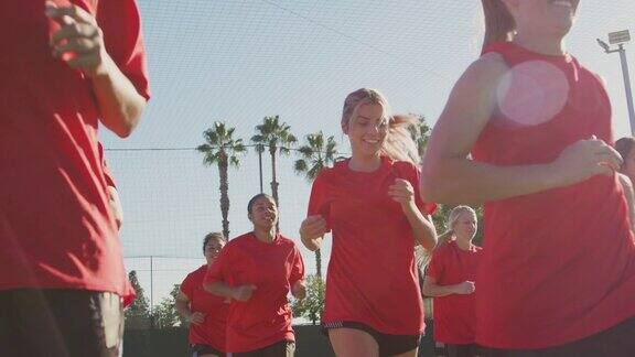 女子足球队在比赛前对着太阳进行热身训练