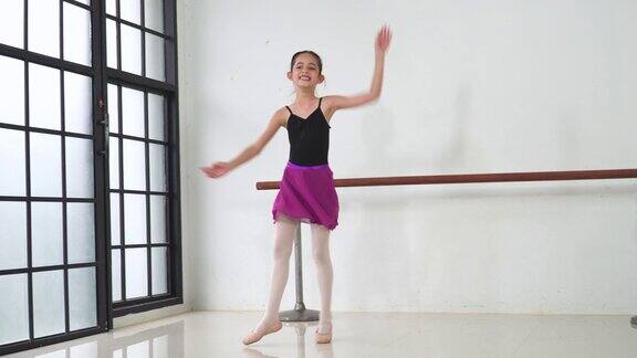 在一个阳光明媚的日子里一位亚洲青少年芭蕾舞者在工作室的课堂上练习、学习芭蕾舞手势带着情绪和微笑休闲活动是孩子在周末的日常活动