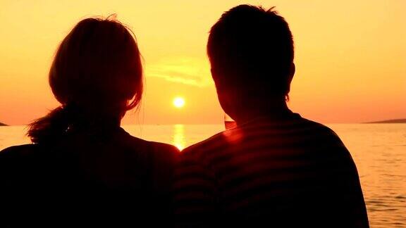 HD:一对情侣在日落时在海滩上接吻