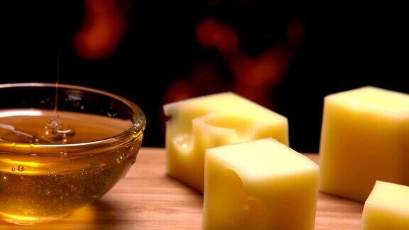 壁炉背景上的一个玻璃碗上面放着蜂蜜和奶酪
