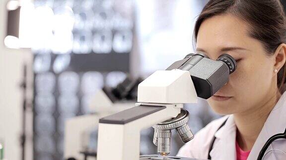 在实验室使用显微镜的医学研究人员