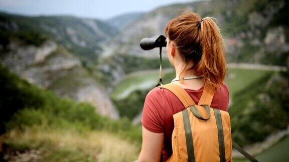 年轻的徒步女郎到达山顶欣赏风景