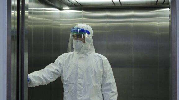 实验室里穿着防护服的男科学家走进医院隔离区的电梯