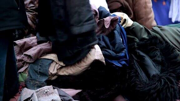 衣服堆为穷人冬季户外男性选择外套