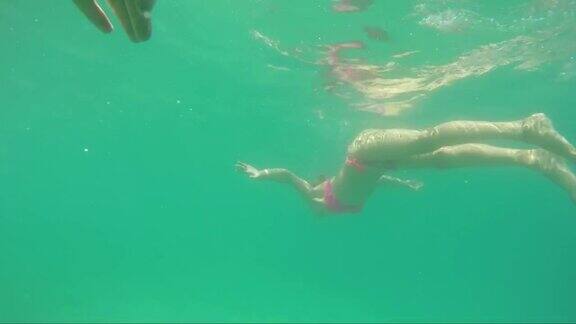 一个穿着粉红色泳衣的女人在爱奥尼亚海中游泳