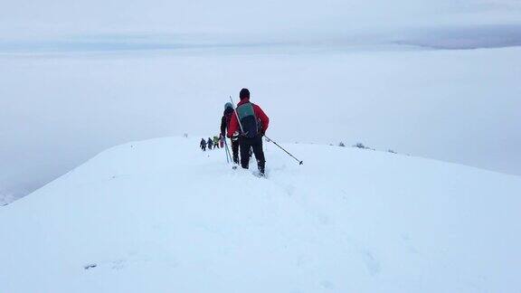 登山队伍在雪地里行走在高山的顶峰上
