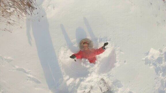 一个小男孩做了一个雪天使冬季休闲活动Slowmotion拍摄