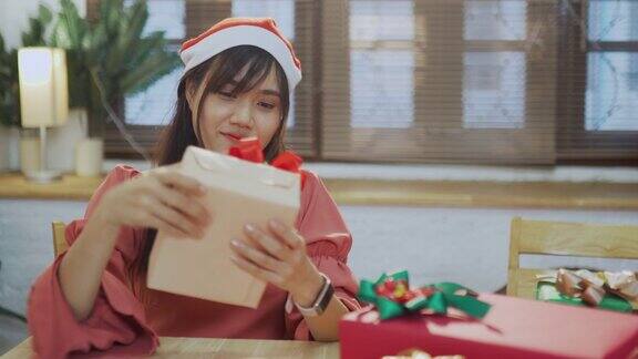 年轻的亚洲妇女在家里包装圣诞礼物盒