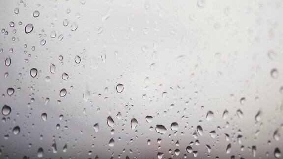 雨点落在有云背景的窗玻璃上