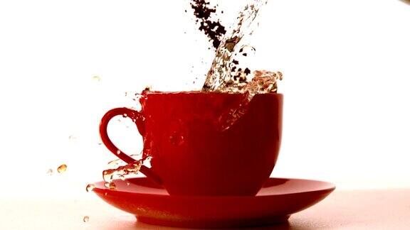 咖啡颗粒和水落入红色杯中