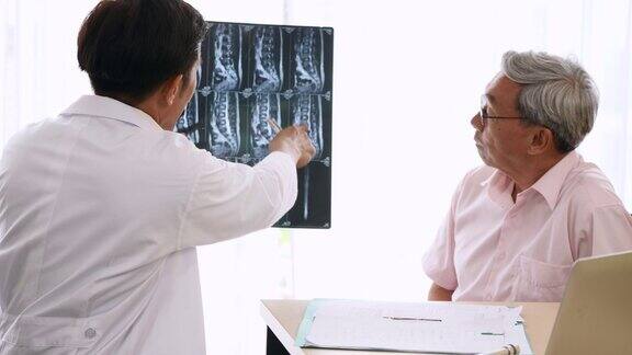 专家医生在医务室为老年患者检查并讲解x光片