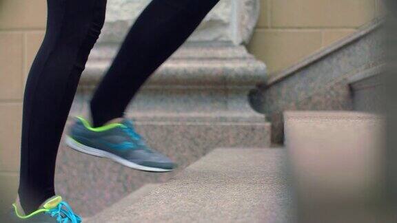 双腿健美的女人和男人穿着运动鞋走上台阶