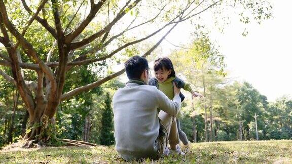 亚洲父亲和女儿在公园放松玩耍