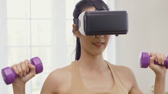 美丽的亚洲妇女与家庭锻炼她在家锻炼时使用虚拟现实技术