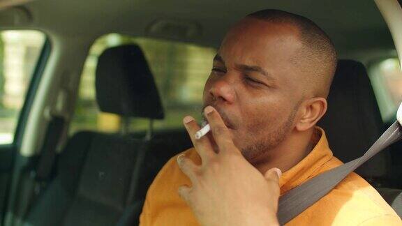 紧张的非洲男性司机在车里抽烟