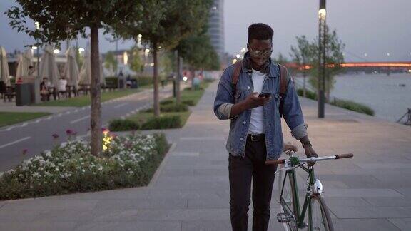 一个年轻人在夜里骑着自行车走在人行道上